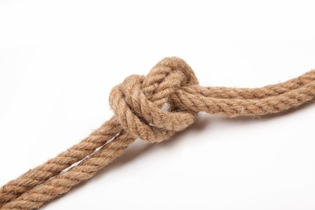 A brown rope tied in a knot on a white background
