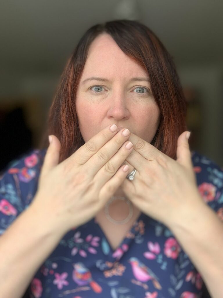 Jude covering her mouth with her hands