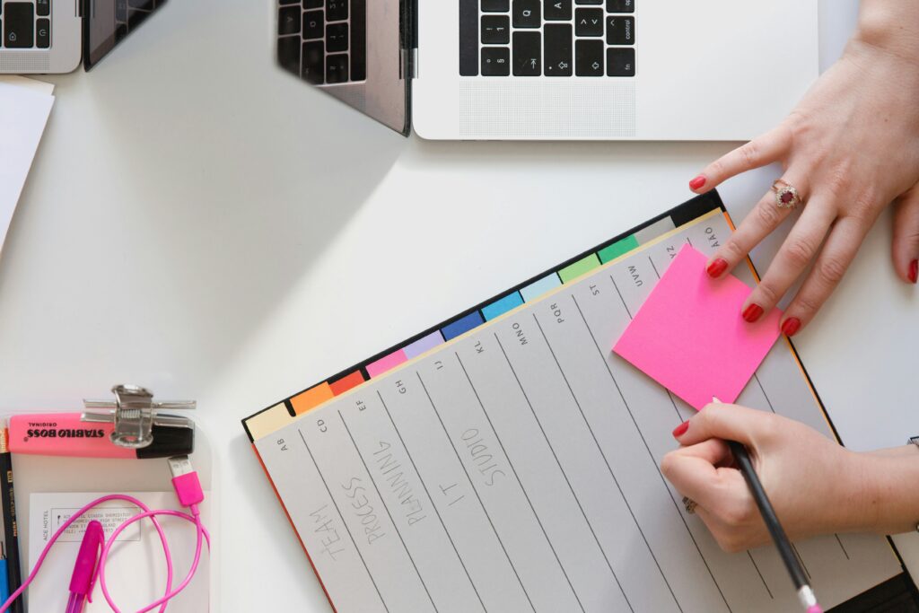 Helping employees set and achieve meaningful goals - a person with a notepad and pen at a desk. Image credit Marten Bjork from Unsplash
